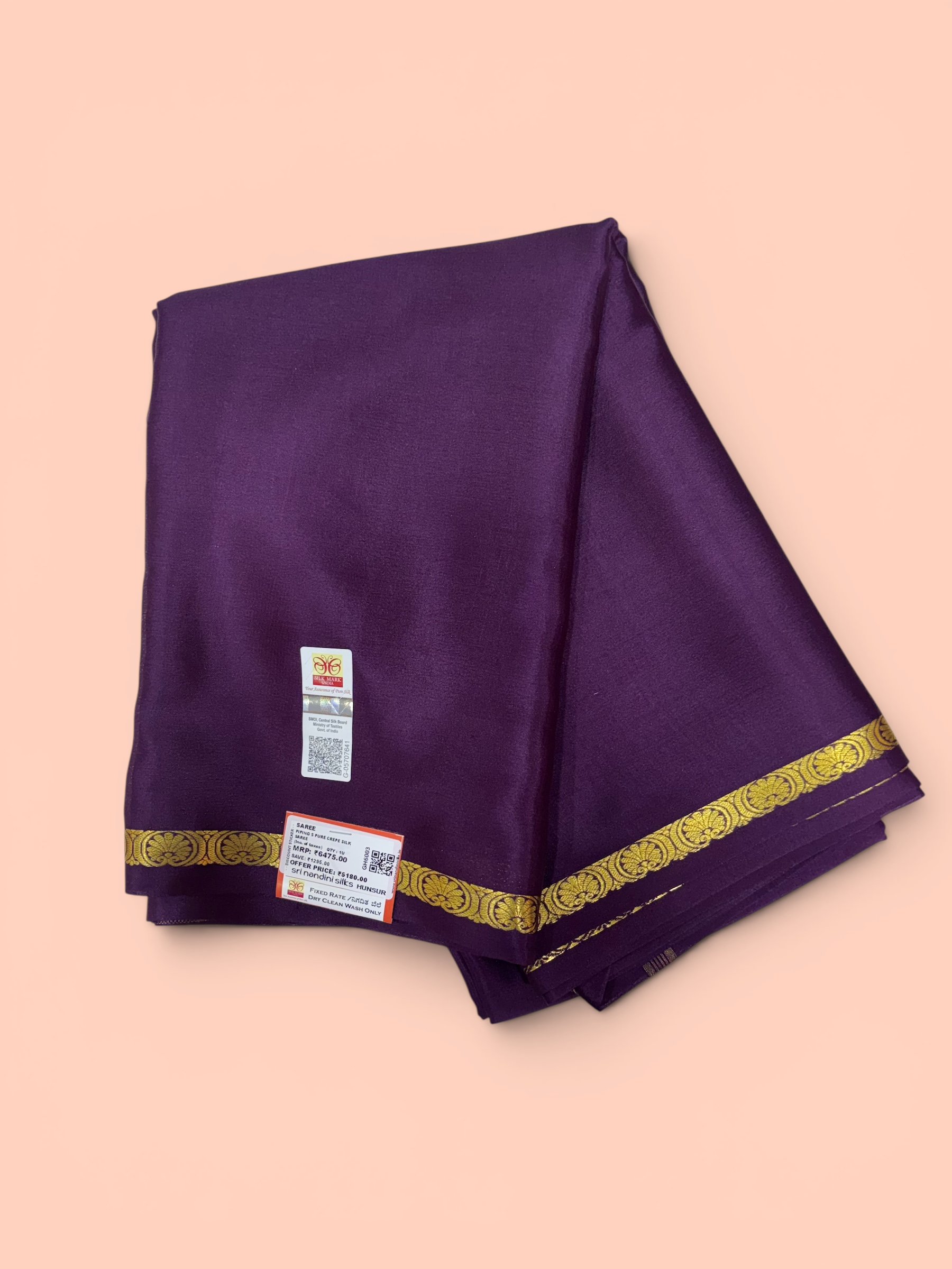 Purple fabric with gold border on a peach background